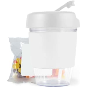 A white reusable coffee cup with a lid, accompanied by a bag of colorful jelly beans.