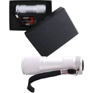 A silver flashlight in a black box, accompanied by batteries and featuring a strap for easy carrying.