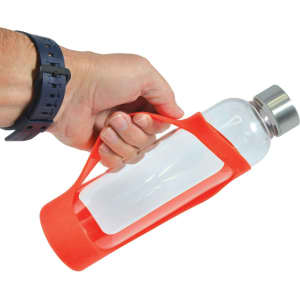 A drink bottle with a clear glass body and a bright red silicone sleeve, held by a hand. It has a metal cap.