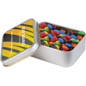 A silver rectangular tin filled with colourful M&M's chocolate candies. The tin has a logo.