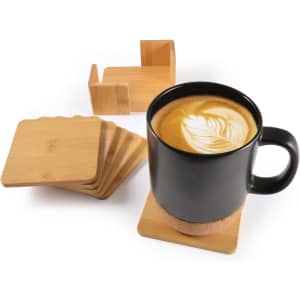 A black mug on a bamboo coaster, surrounded by a set of five additional bamboo coasters.