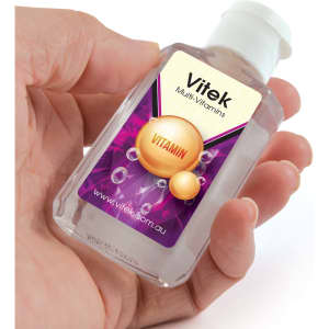 A hand holds a small clear bottle of gel sanitizer with a vibrant purple label featuring bubbles and a logo.