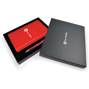 A red notebook and a silver pen in a sleek black gift box, featuring a branding logo.