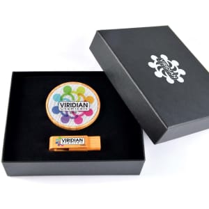 A black gift box containing a round coaster and an orange flash drive, both featuring colourful branding.
