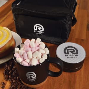A black coffee mug filled with pink and white marshmallows, alongside a silver container and a black carry bag.