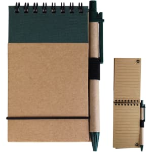 A cardboard notebook with a green cover and a pen attached. The notebook features a coil binding and lined pages.