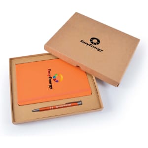 An orange notebook and a grey pen within a brown cardboard gift set, featuring a logo.