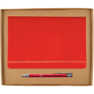 A red notebook with an elastic band and a silver pen are neatly presented in a cardboard gift box.