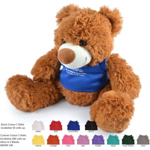 A fluffy brown teddy bear wearing a blue shirt, with various coloured t-shirts displayed below. It has a logo on the shirt.