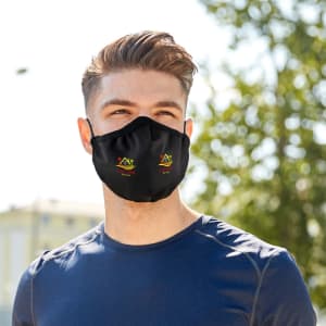 A black cooling face mask featuring a logo, worn by a man outdoors in a casual setting.