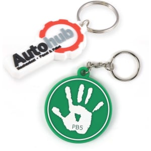 Two keytags, one white with a logo and the other green featuring a handprint design, both attached to keyrings.