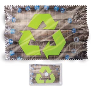 A green recycled symbol on a microfibre lens cloth, surrounded by blue bottle caps, set against a wooden background.