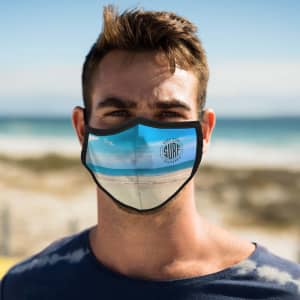 A face mask featuring a beach scene design, predominantly blue, with a logo on the front.