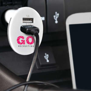 A white USB car charger with a cable connected, fitted into a vehicle's port, featuring a logo.
