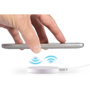 A wireless charger with a white circular base and a smartphone hovering above it, indicating charging.