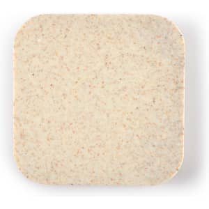 A wireless charger hub with a smooth, square surface featuring a light beige color with a subtle speckled texture.