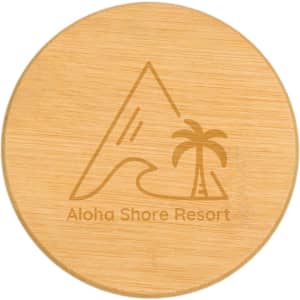 A round bamboo coaster with a engraved design of a mountain and palm tree, featuring a logo.