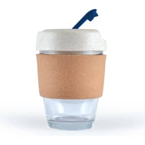 A reusable coffee cup in transparent glass with a cork band and a white lid featuring a blue straw.
