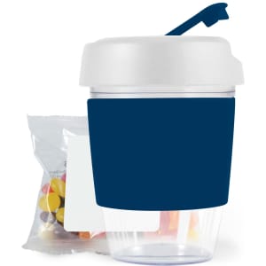 A reusable coffee cup with a dark blue sleeve and a white lid, accompanied by a pack of colorful jelly beans.