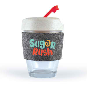 A reusable coffee cup in clear glass with a grey RPET band and a red straw. It features colorful text.