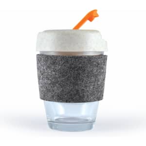 A reusable coffee cup with a clear glass base, a grey felt band, and a white lid with an orange straw.