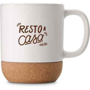 A white ceramic mug with a cork base, featuring text and a logo design.