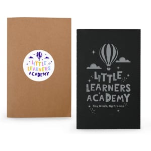 A brown notebook with a circular logo and a black notebook featuring a balloon design and grey text.