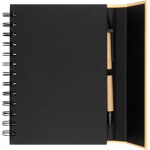 A black spiral-bound notebook with a pen positioned inside. The notebook has a smooth cover and a plain interior.