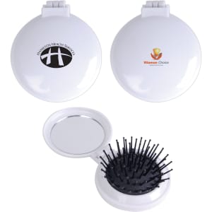 A compact pop-up brush and mirror set in white featuring a logo, with a bristle brush on one side and a mirror inside.