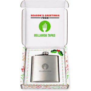 A drink bottle in a gift box, featuring a stainless steel hip flask and a festive interior design.
