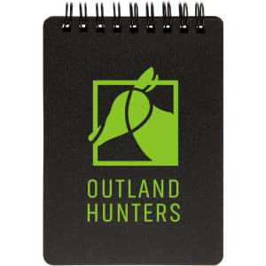 A spiral-bound pocket notebook featuring a black cover and a green logo with the text "OUTLAND HUNTERS."