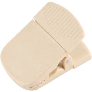 A beige magnetic clip with a textured grip, designed for holding notes or papers, featuring a branding logo.