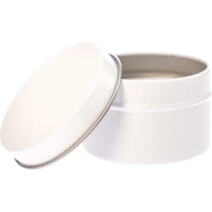 A petite candle in a white tin container with a removable lid.