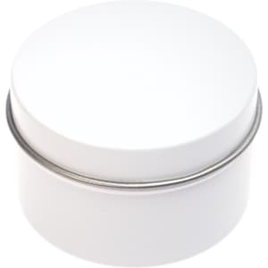 A petite candle in a white tin container with a smooth, rounded lid.