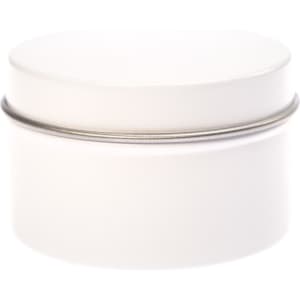 A petite candle in a simple, white tin container with a smooth lid. The tin is cylindrical in shape.