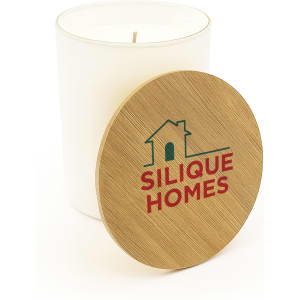 A medium glass candle with a wooden lid, featuring a logo, placed inside a white container.