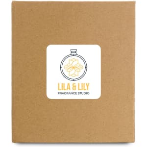 A large candle packaged in a simple brown box featuring a label with the logo of Lila & Lily Fragrance Studio.