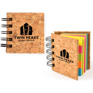 A cork-covered notepad featuring colourful sticky notes in pink, yellow, and green, with a logo on the cover.