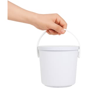 A hand holding a white bucket with a handle, positioned against a plain background.