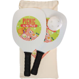 A pickleball set featuring two paddles with a picnic theme, a white ball, and a beige storage bag.
