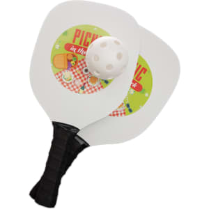 A pickleball set featuring two paddles with colorful picnic-themed graphics and a perforated pickleball.