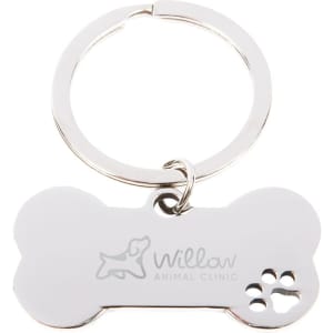 A metallic dog bone keytag with a keyring, featuring a logo and a paw print design.