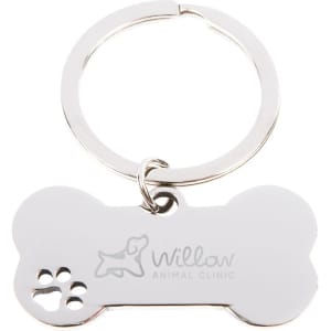 A silver keytag shaped like a dog bone with a small paw print design and a logo.