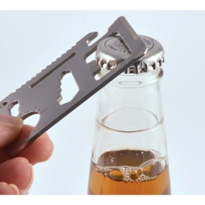 A silver multi-tool is positioned over a bottle cap, ready to open a beverage.