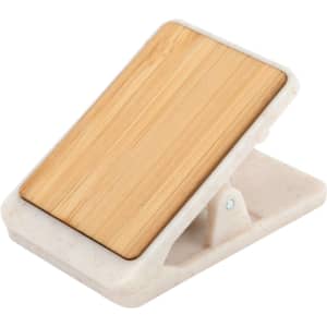 A magnetic clip with a bamboo top and a white base, featuring a logo. Ideal for office use and organising papers.