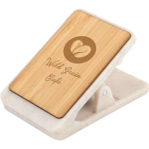 A magnetic clip with a bamboo surface and a white base, featuring a logo and a decorative design.