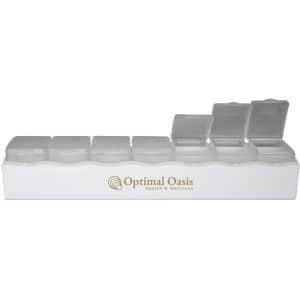 A white weekly pill box featuring multiple clear compartments and a logo.