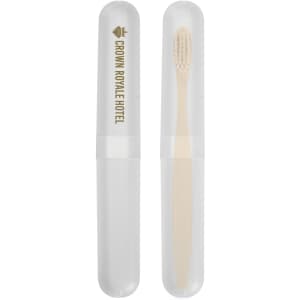 A toothbrush case featuring a transparent exterior and a bamboo toothbrush inside, labeled with "Crown Royale Hotel."