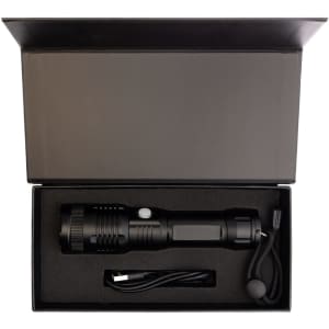 A black rechargeable torch in a black box with a USB charging cable and a lanyard. The box is open.