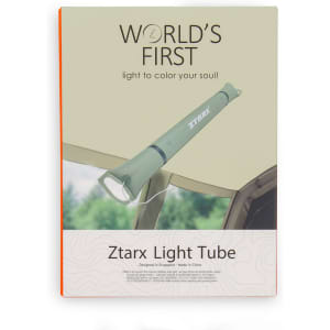 A green foldable camp light is displayed against a natural background, featuring a logo on the product.